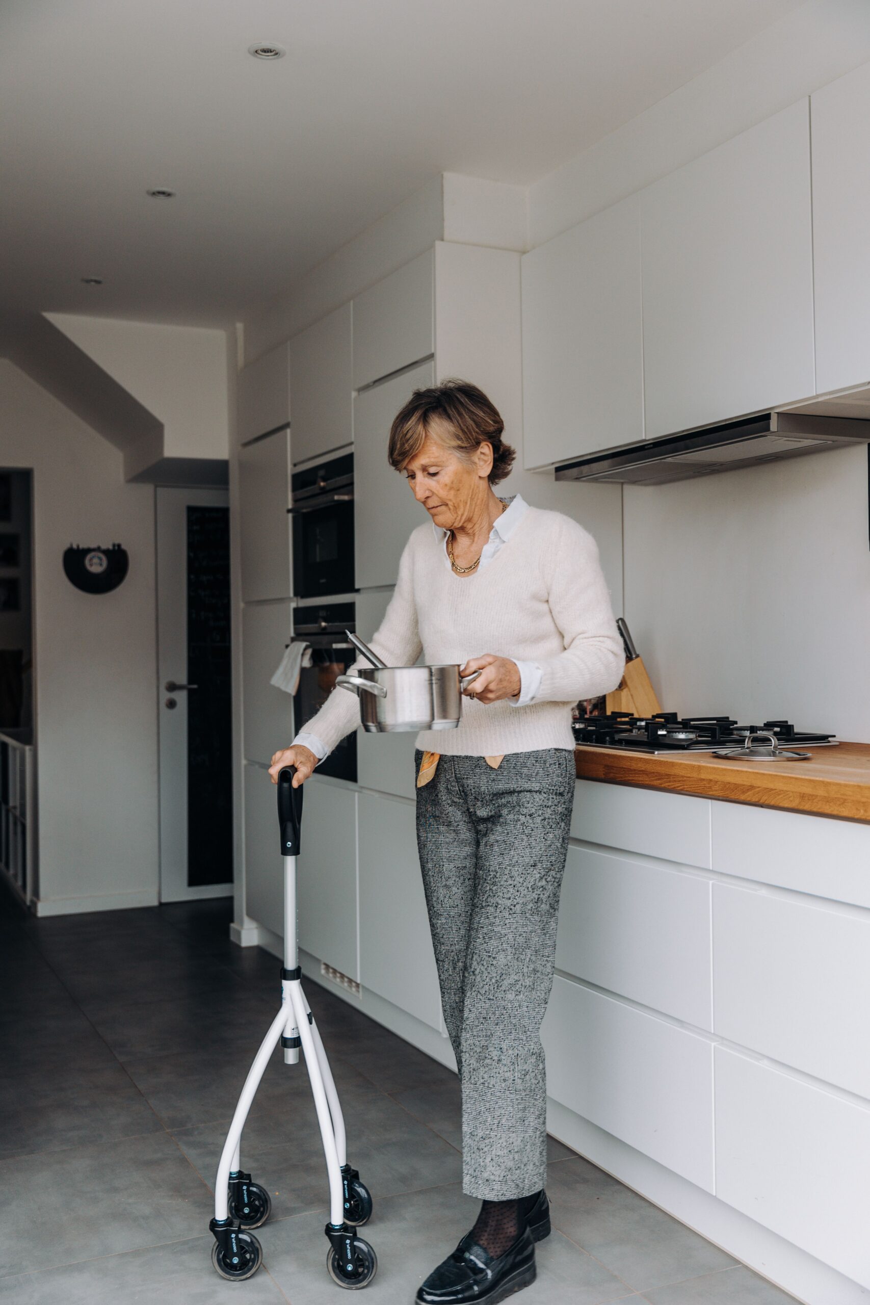 Senior woman using a walker at home, representing independent living supported by long-term care coverage