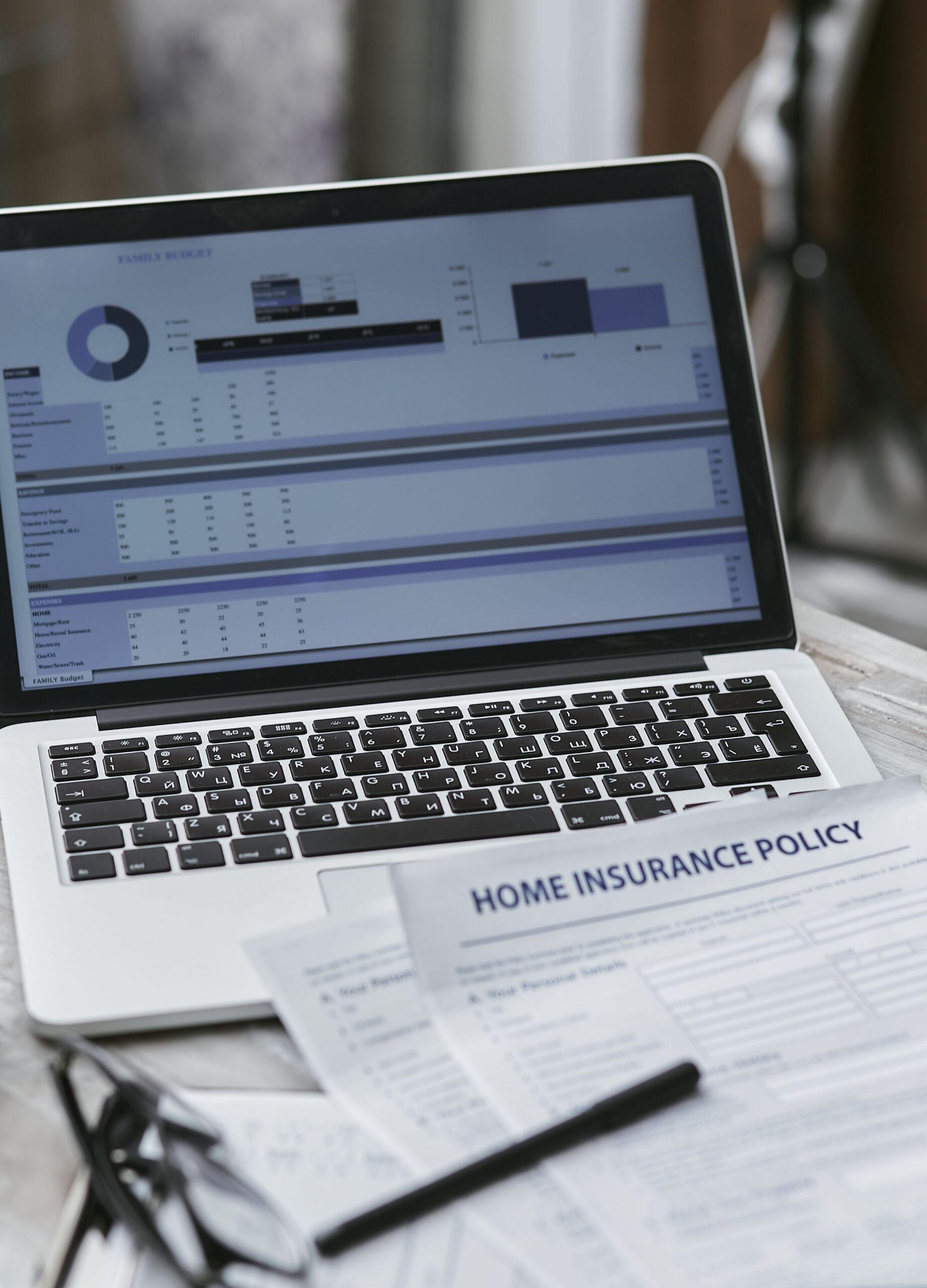 Laptop and insurance policy documents on a table, representing long-term care insurance cost planning