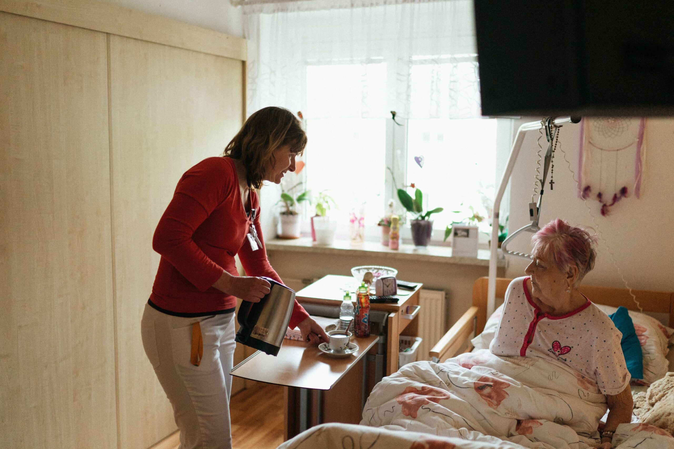 Caregiver assisting an older adult at home, representing long-term care coverage in action