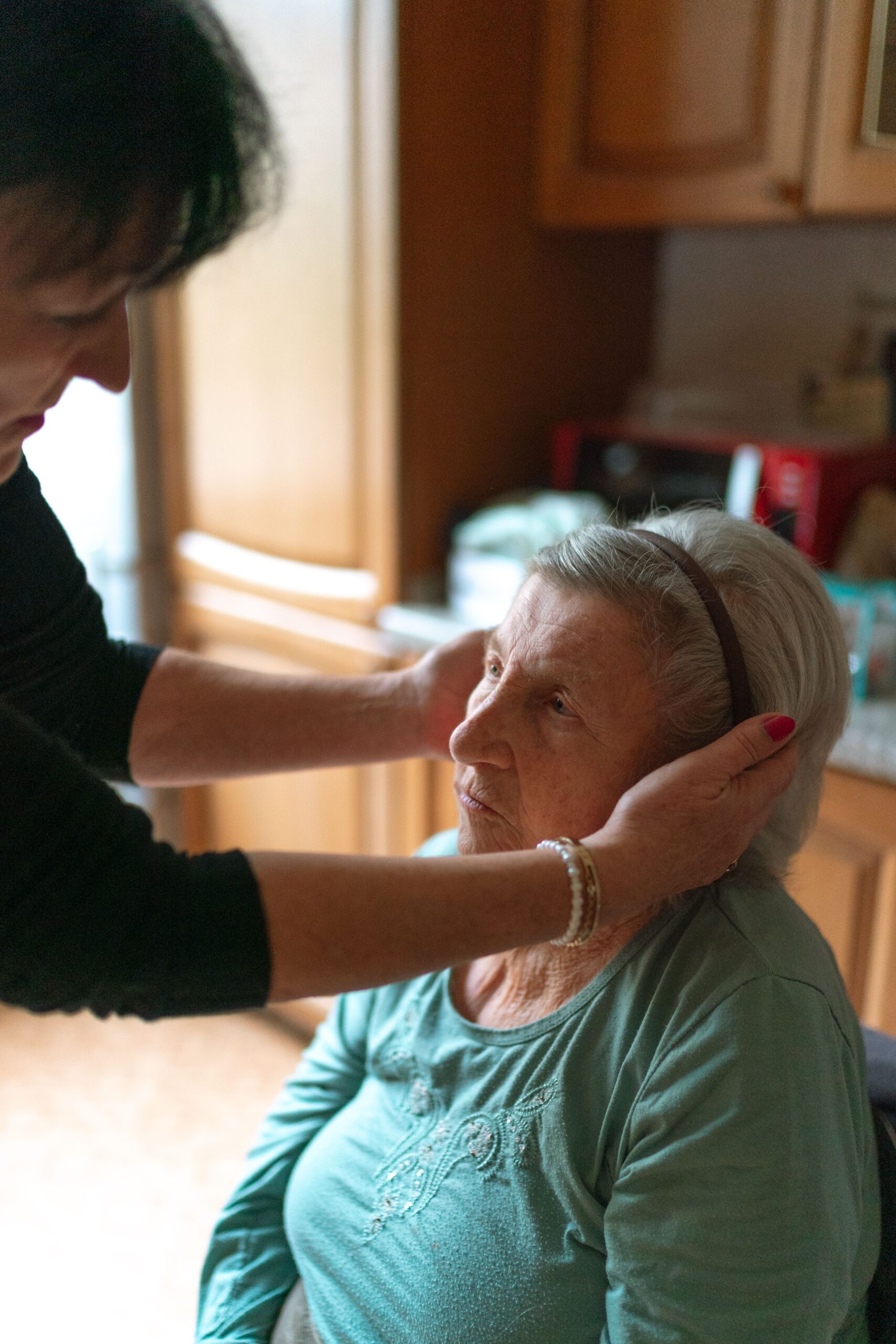 Caregiver helping an older adult get dressed, illustrating activities of daily living