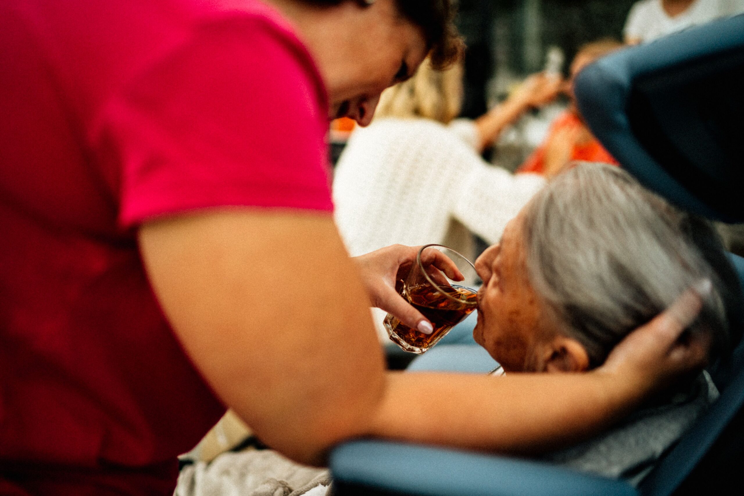 Home caregiver assisting an older adult with a daily task at home