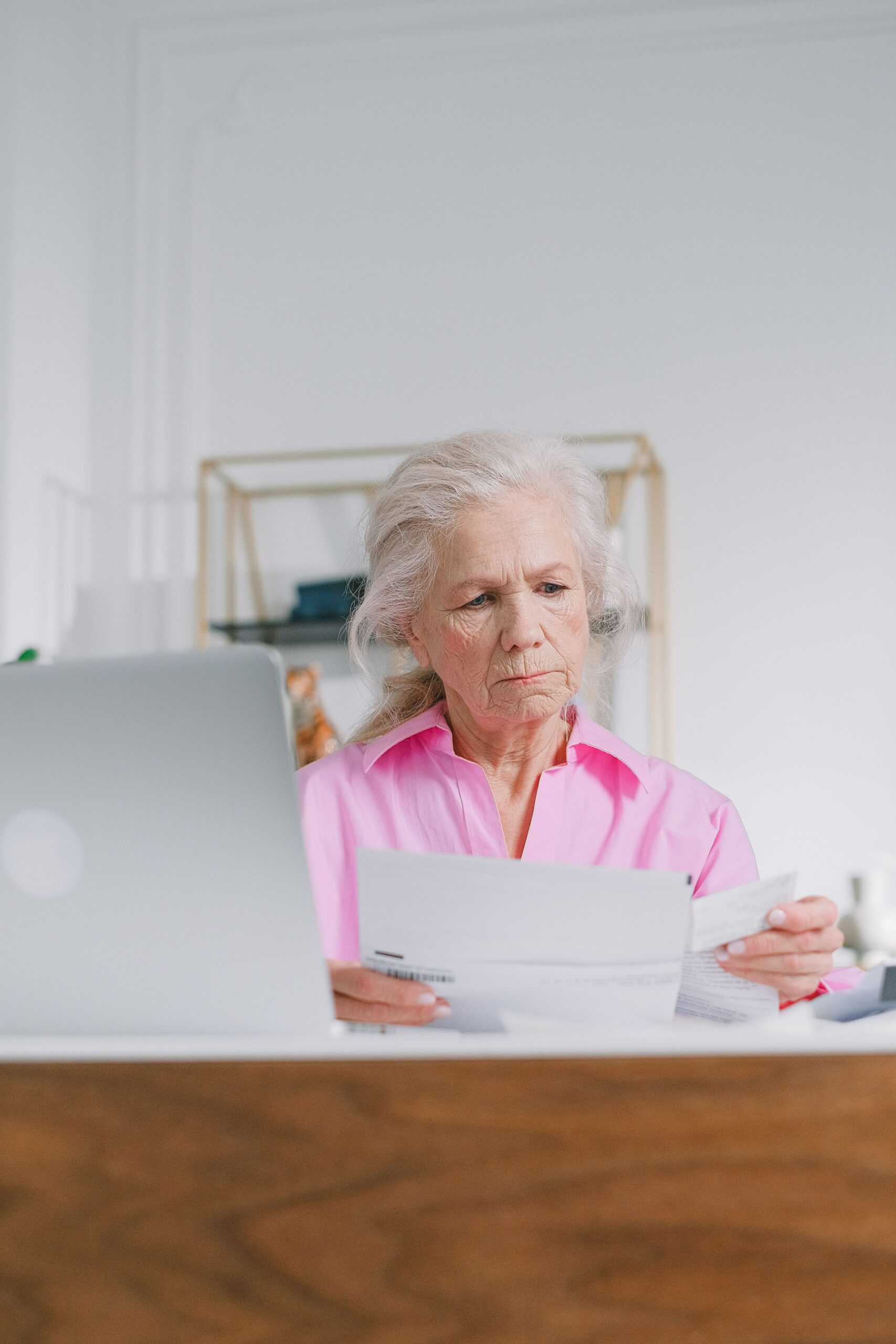 Older adult reviewing a letter about a higher long-term care insurance premium at home